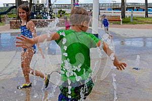 Children playing in an outdoor water splash pad