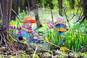 Children playing outdoors catching frog