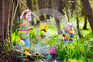 Children playing outdoors catching frog