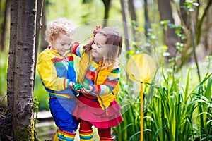 Children playing outdoors catching frog