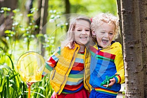 Children playing outdoors catching frog