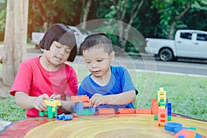 Children playing with plastic bricks on a marble table Educational toys for school-age and kindergarten children