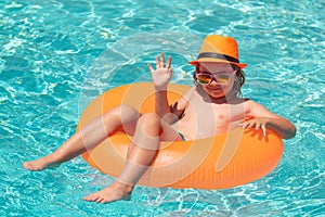 Children playing in pool. Child relaxing in pool. Kid swimming with float ring in water pool.