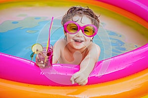 Children playing in pool. Child water toys. Stylish sunglasses. Beach Clubs in Ibiza. Beach party. Child swimming pool