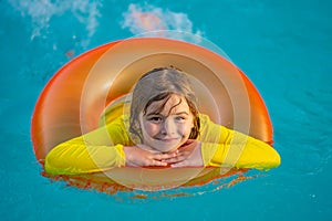 Children playing in pool. Happy young child enjoying summer vacation outdoors in water in the swimming pool. Cute little