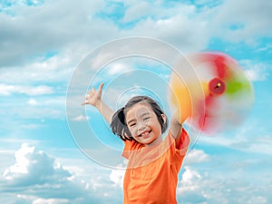 Children playing rainbow pinwheel or windmill on nature, happy kids smiling and funny on pinwheel and windy on rice field