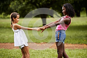 Children playing ring around the rosie in park