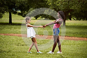 Children playing ring around the rosie in park