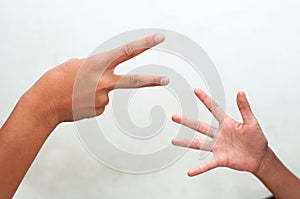 Children playing rock, paper and scissors game cheerily.