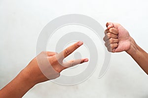 Children playing rock, paper and scissors game cheerily.