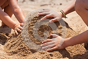 Children playing with sand building a castle
