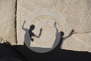 Children playing with shadow at a rock in Joshua tree national park