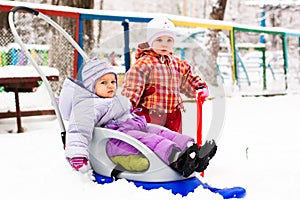 Children playing with sled and spade in snow