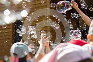 Children playing with soap bubbles in kindergarten outdoor