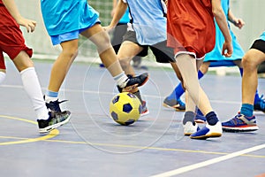 Children playing soccer indoors