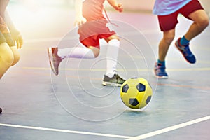 Children playing soccer indoors