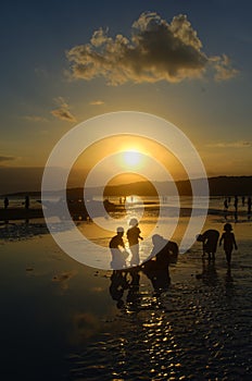 Children playing at sunset on the beach