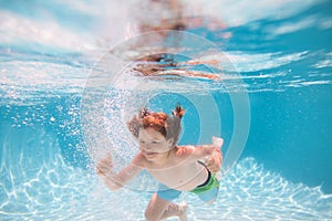 Children playing in swimming pool. Child swim under water in sea. Kid swimming in pool underwater. Happy boy swims in