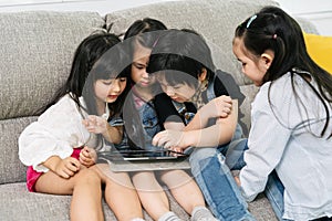 Children playing on tablet. Group of kids playing with laptop together.