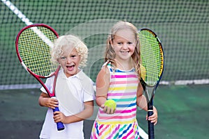 Children playing tennis on outdoor court