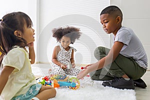 Children playing with their friends on the floor, Kids girls and boy playing toys and game in living room