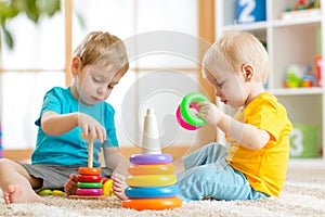 Children playing together. Toddler kid and baby play with blocks. Educational toys for preschool kindergarten child