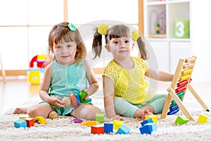 Children playing together. Toddler kid and baby play with blocks. Educational toys for preschool and kindergarten child. Little gi