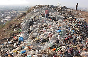 children playing on top of the hill made up of trash photo