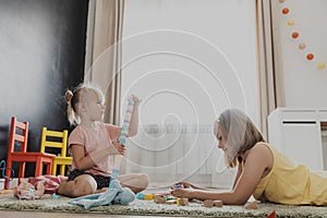 Children playing with toy building blocks on the floor at home or kindergarten