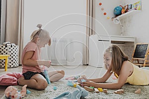 Children playing with toy building blocks on the floor at home or kindergarten