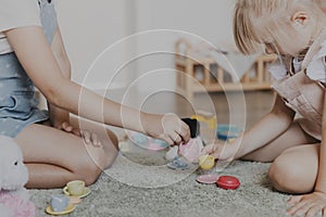 Children playing with toy play tea set on the floor at home or kindergarten