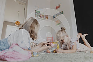 Children playing with toy play tea set on the floor at home or kindergarten