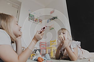 Children playing with toy play tea set on the floor at home or kindergarten