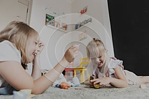 Children playing with toy play tea set on the floor at home or kindergarten