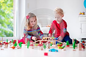 Children playing with toy railroad and train