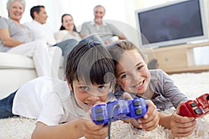 Children playing video games and family on sofa