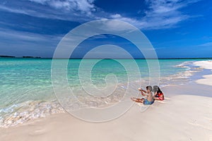 Children playing on white sandy Cuban beach in Cayo Coco