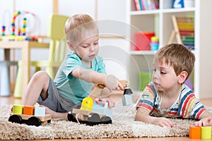 Children playing with wooden car at home or daycare. Educational toys for preschool and kindergarten kid.