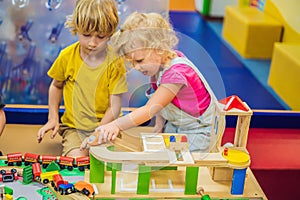 Children playing with wooden train. Toddler kid and baby play with blocks, trains and cars. Educational toys for