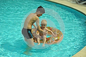 Children at pool, happiness and joy. Two brothers having fun swimming ring