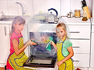 Children poorly cooking chicken at kitchen.