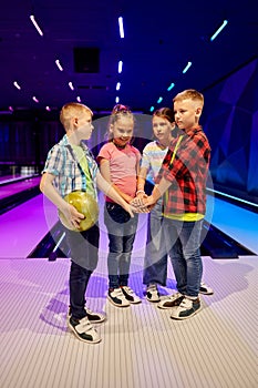 Children poses on the lane in bowling alley