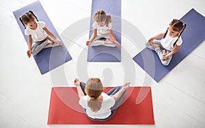 Children practicing engaged in gymnastics and yoga with teacher