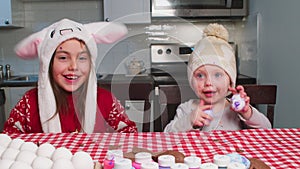 Children prepare for the Easter holiday at home in the kitchen.