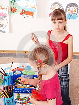 Children prescooler with pencil in play room.