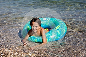 Children, preteen boys, playing on the beach with inflatable ring, having fun