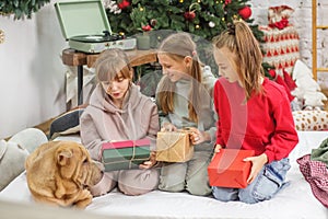 Children preteen opening magic Christmas gift at home. Merry Christmas and Happy Holidays