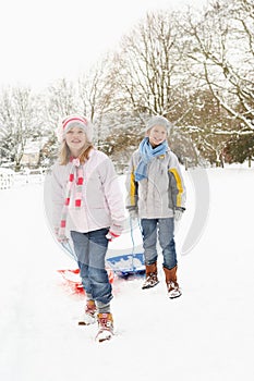 Children Pulling Sledge Through Snowy Landscape