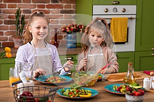 Children In Pyjamas Making Pancakes In Kitchen At Home Following Recipe On Digital Tablet