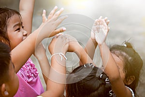 Children raise hands and playing together